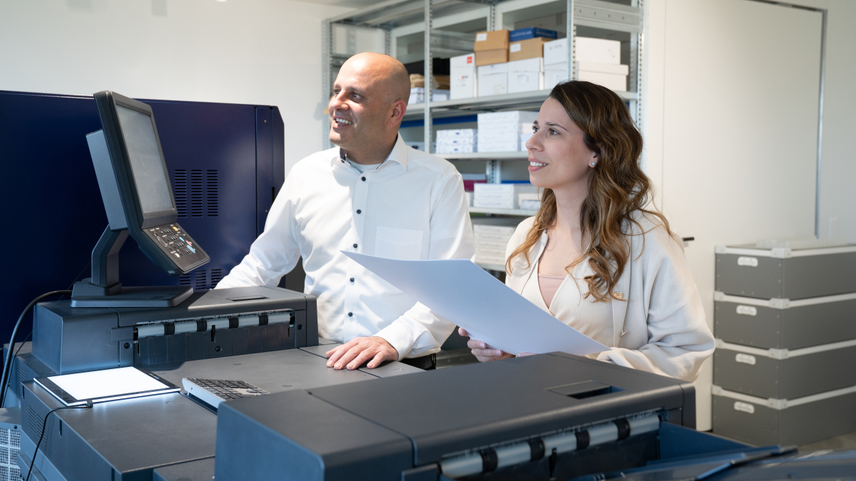 zwei Personen an der Druckmaschine